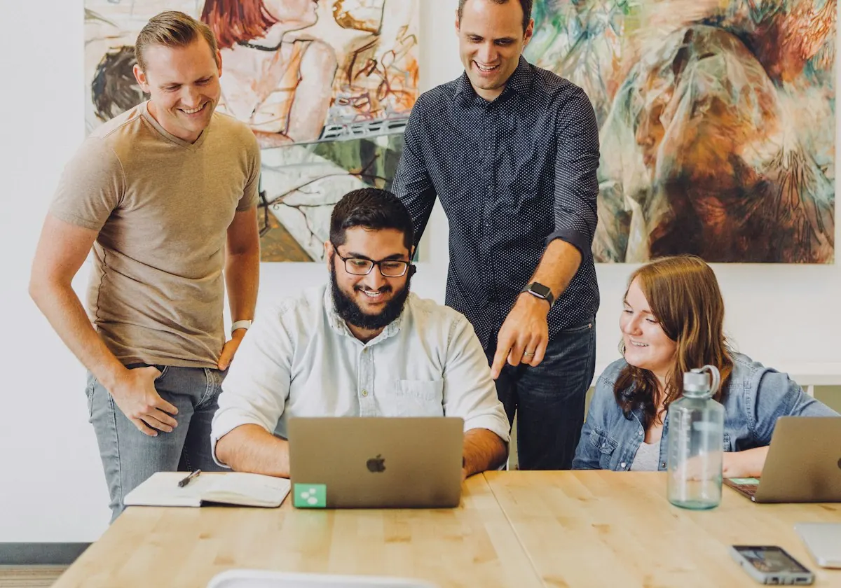 Team members reviewing work on a laptop