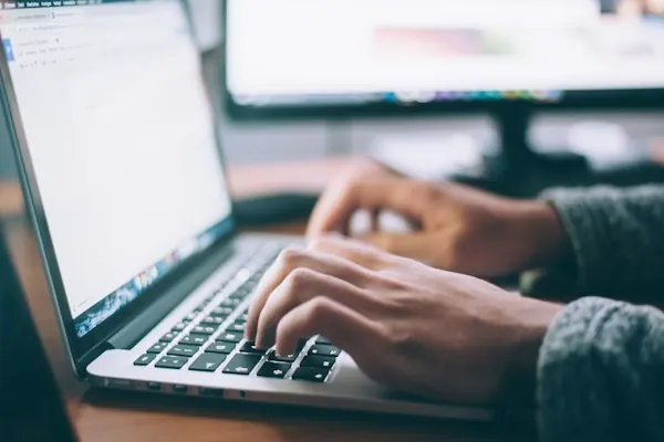 Person typing an email on a laptop