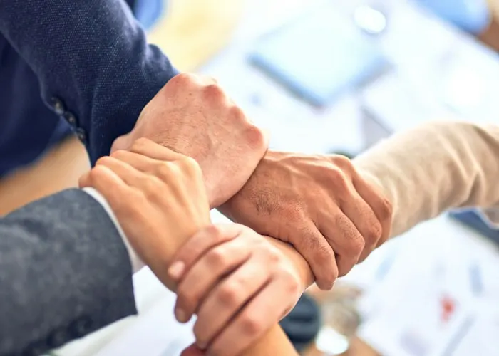 Team members joining hands