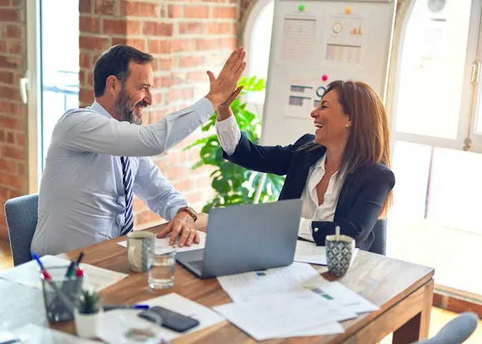 Two colleagues celebrating with a high five